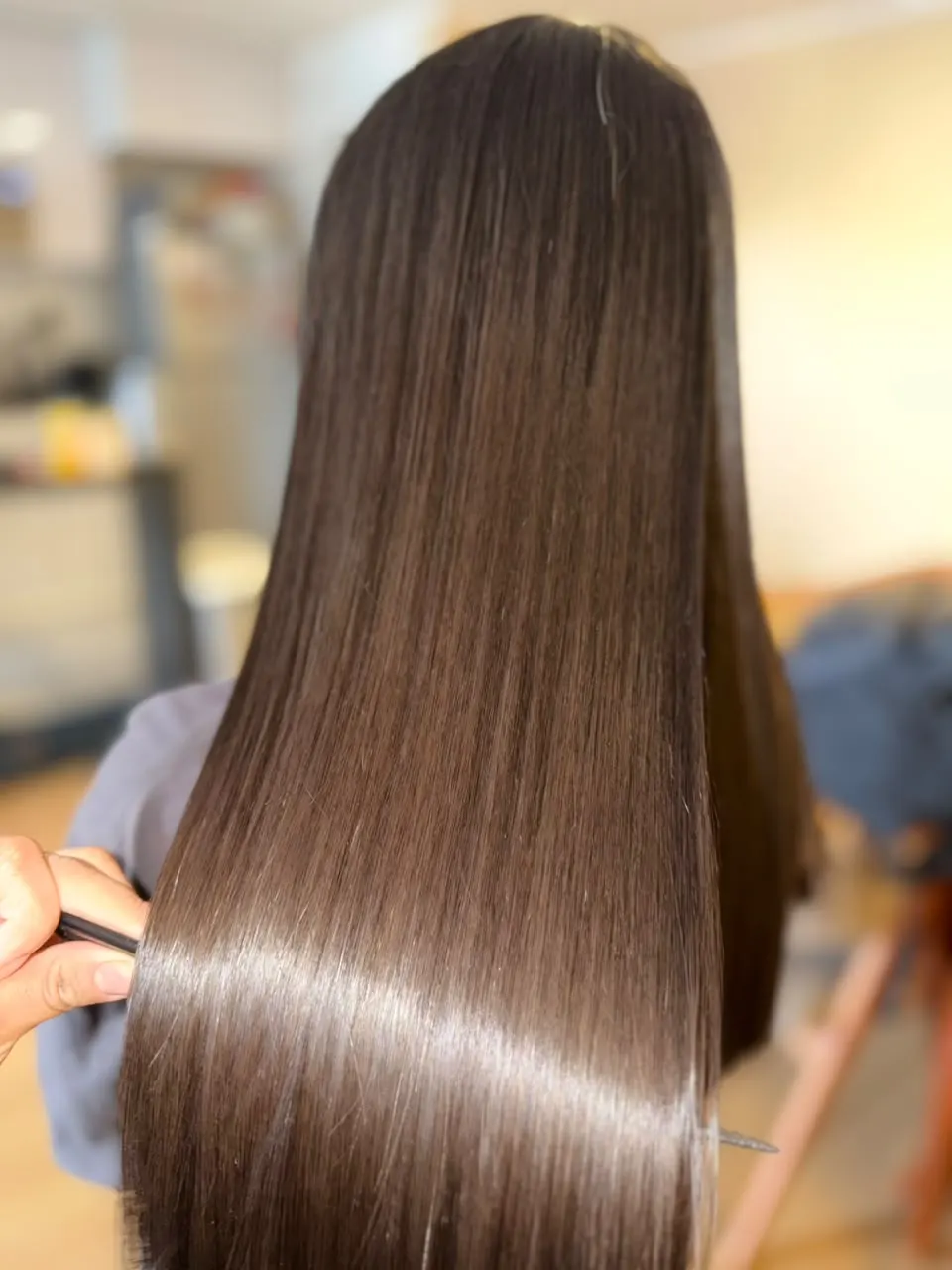Cabello castaño con brillo espejo y sin frizz después de un alisado en Lima